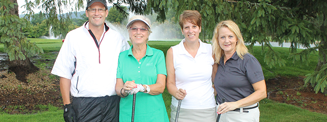 A man and three women on a golf course