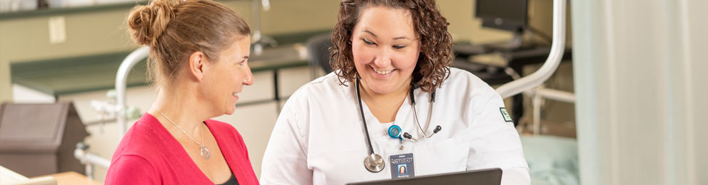 Nursing instructor talking to nursing student in simulation lab
