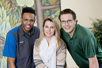 Three students smiling at the camera