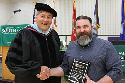 Interim President Larry Lundblad shakes hands with Mike Corrigan