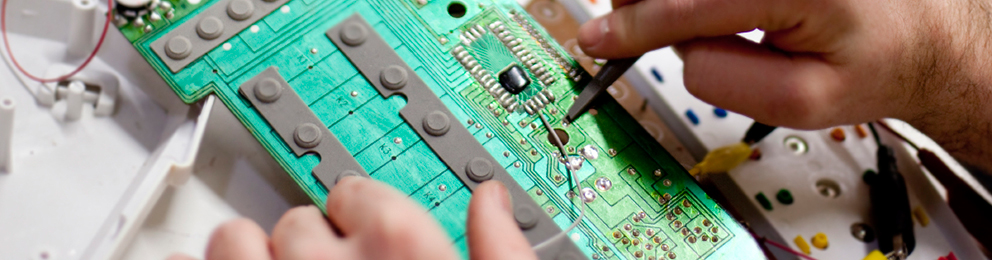 Closeup of hands working on a circuit board