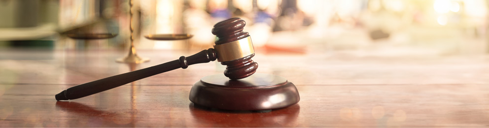 wooden gavel resting on a wood pedestal 