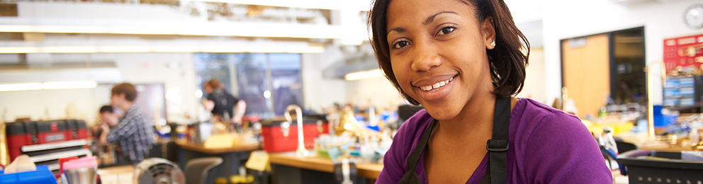 Student smiling in a instrument repair lab